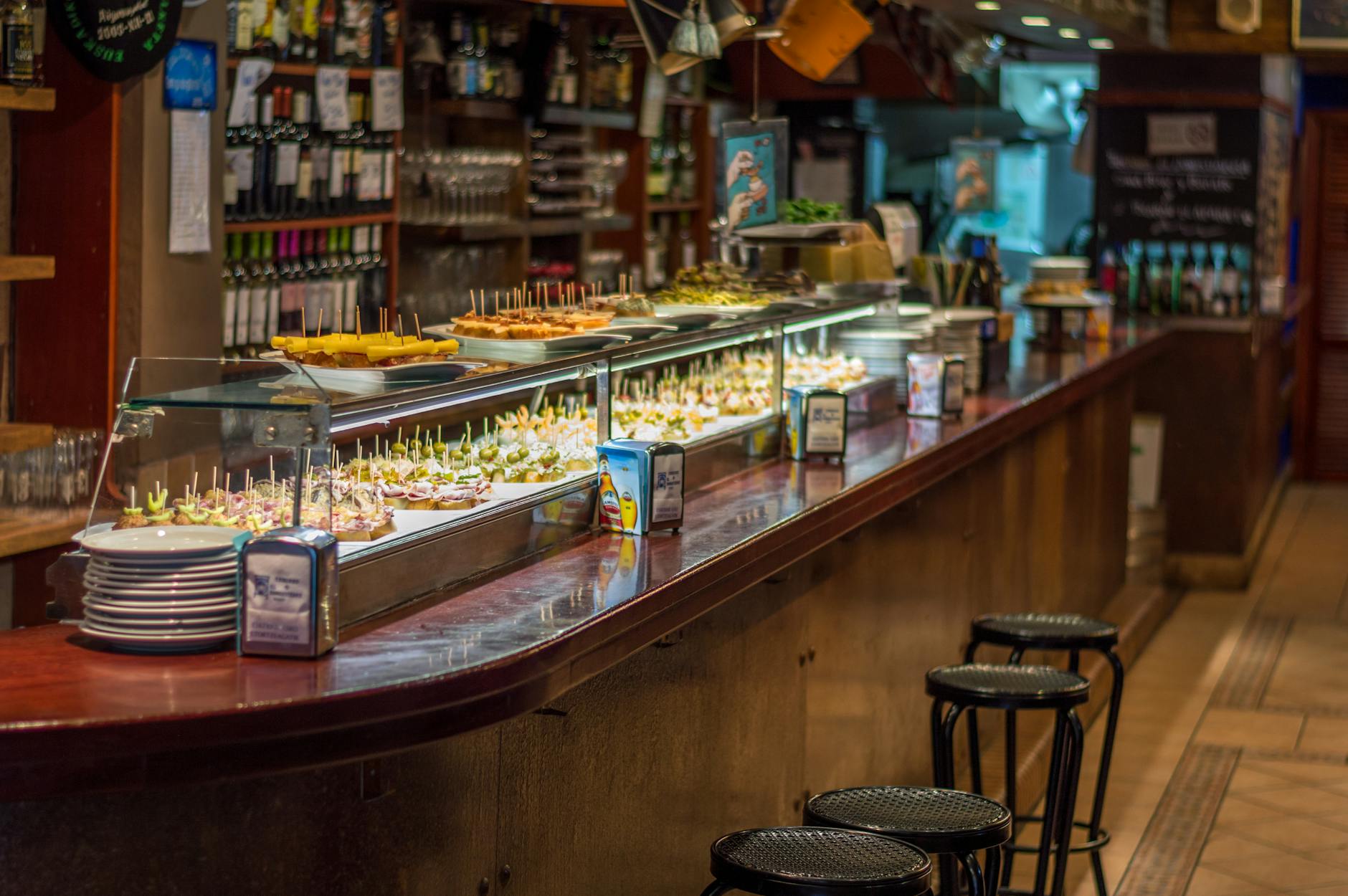 Bar w Barcelonie z kolorowymi pinchos ułożonymi na barze