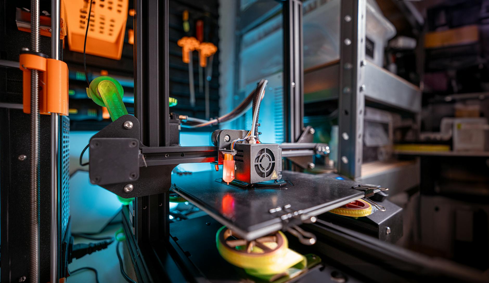 Drukarka 3D pracująca w warsztacie, zbliżenie na głowicę drukującą