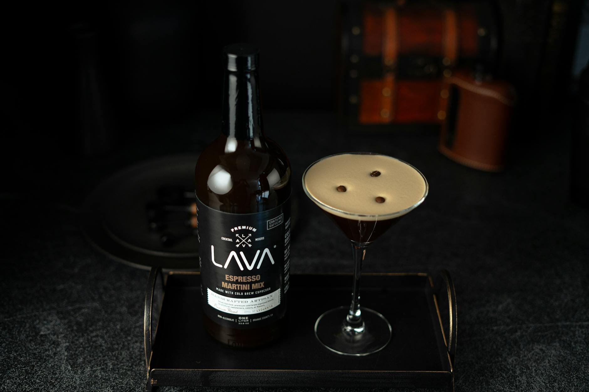 Espresso martini w kieliszku i butelka likieru kawowego na tacy
