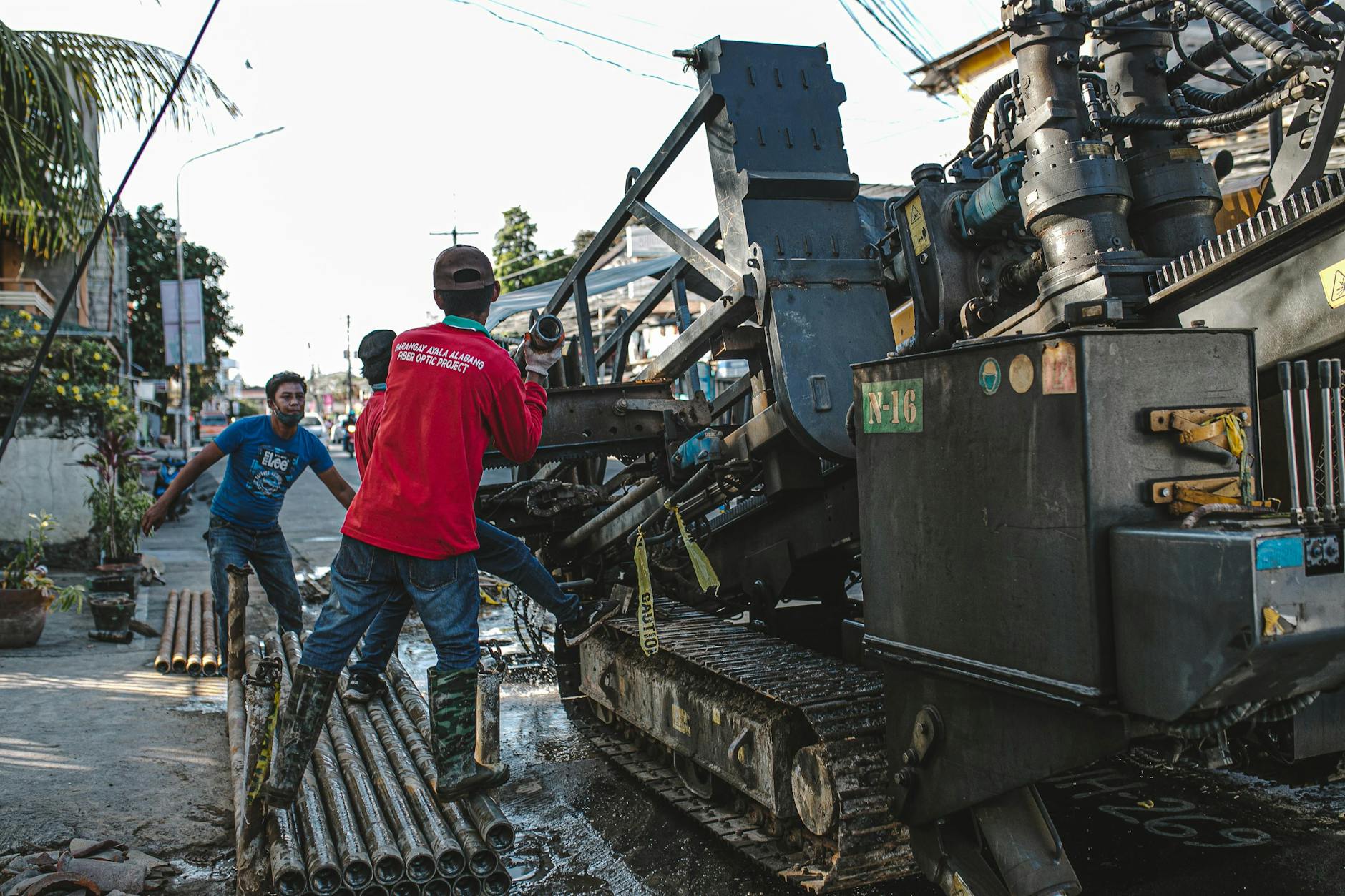 Pracownicy na ulicy obsługują ciężką maszynę do wiercenia nawierzchni