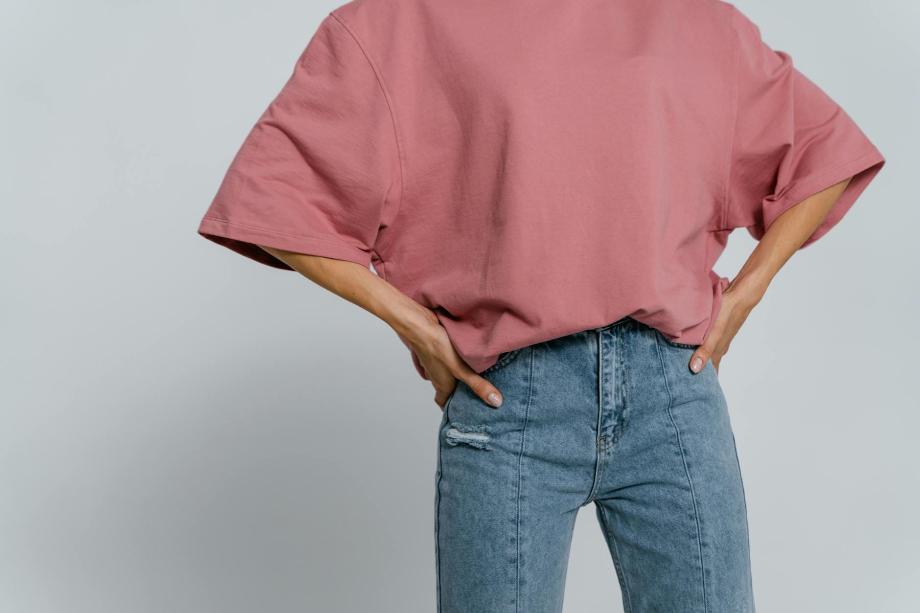 Różowy t-shirt oversize i jeansy w minimalistycznej stylizacji casual